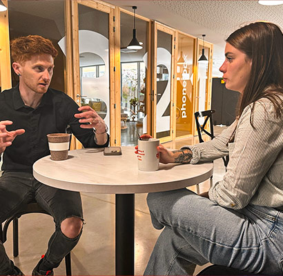 Discussion stratégique entre Fabien et Margerie Fabien échange avec Margerie autour d’un café lors d’une réunion informelle chez Tizy